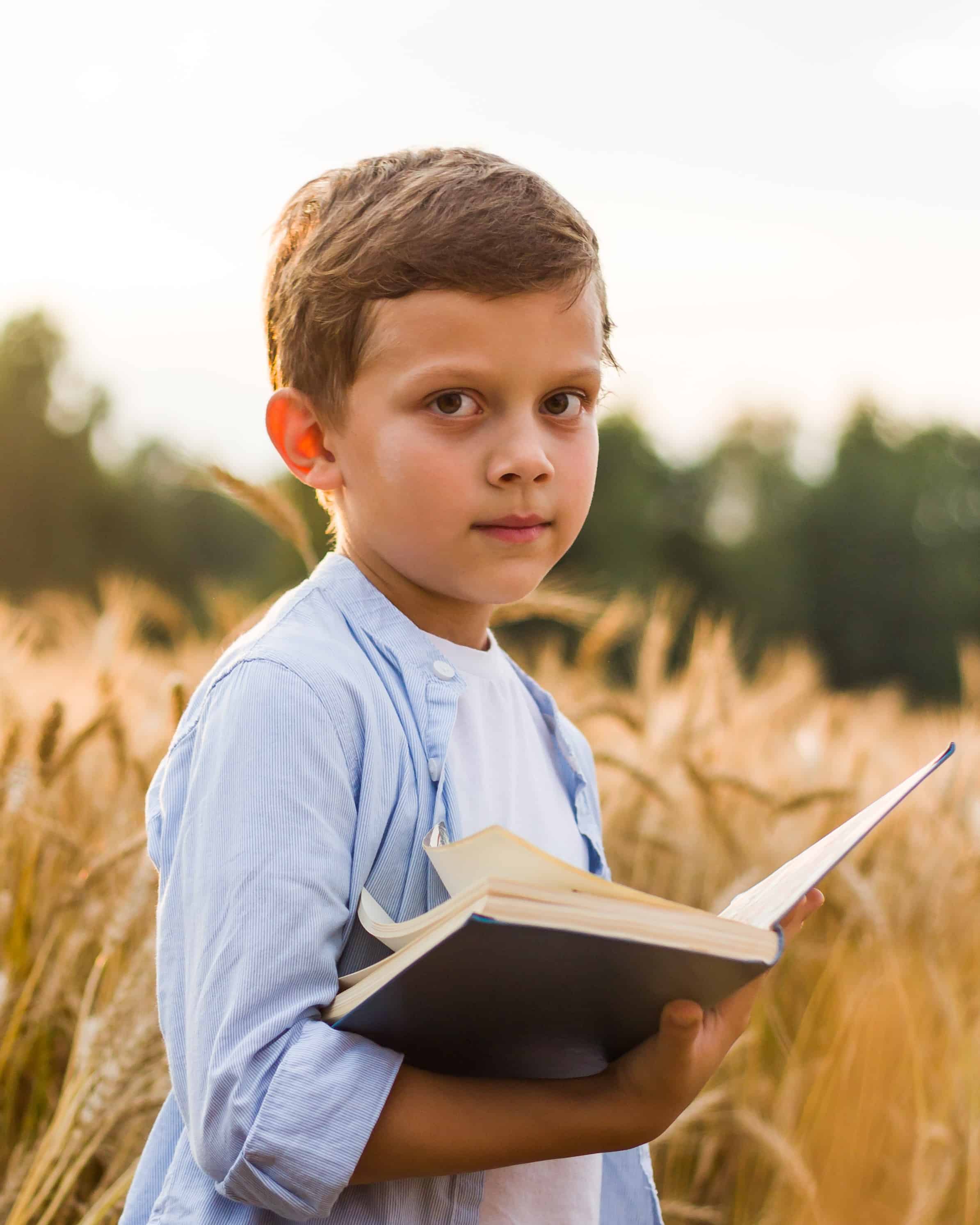Boy outside reading a book