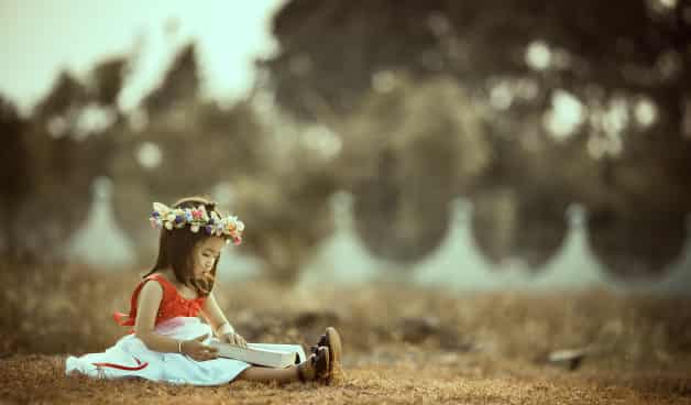 Child reading a book outside