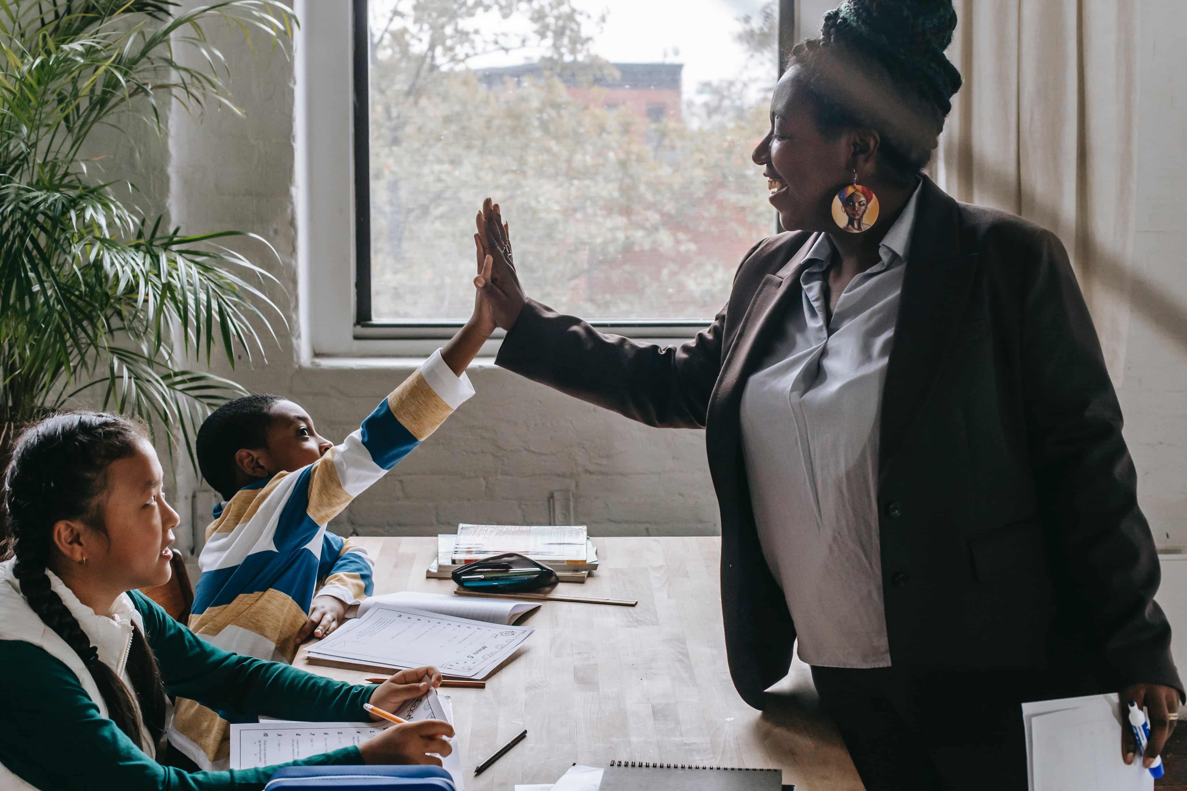 Teacher gives high five to child