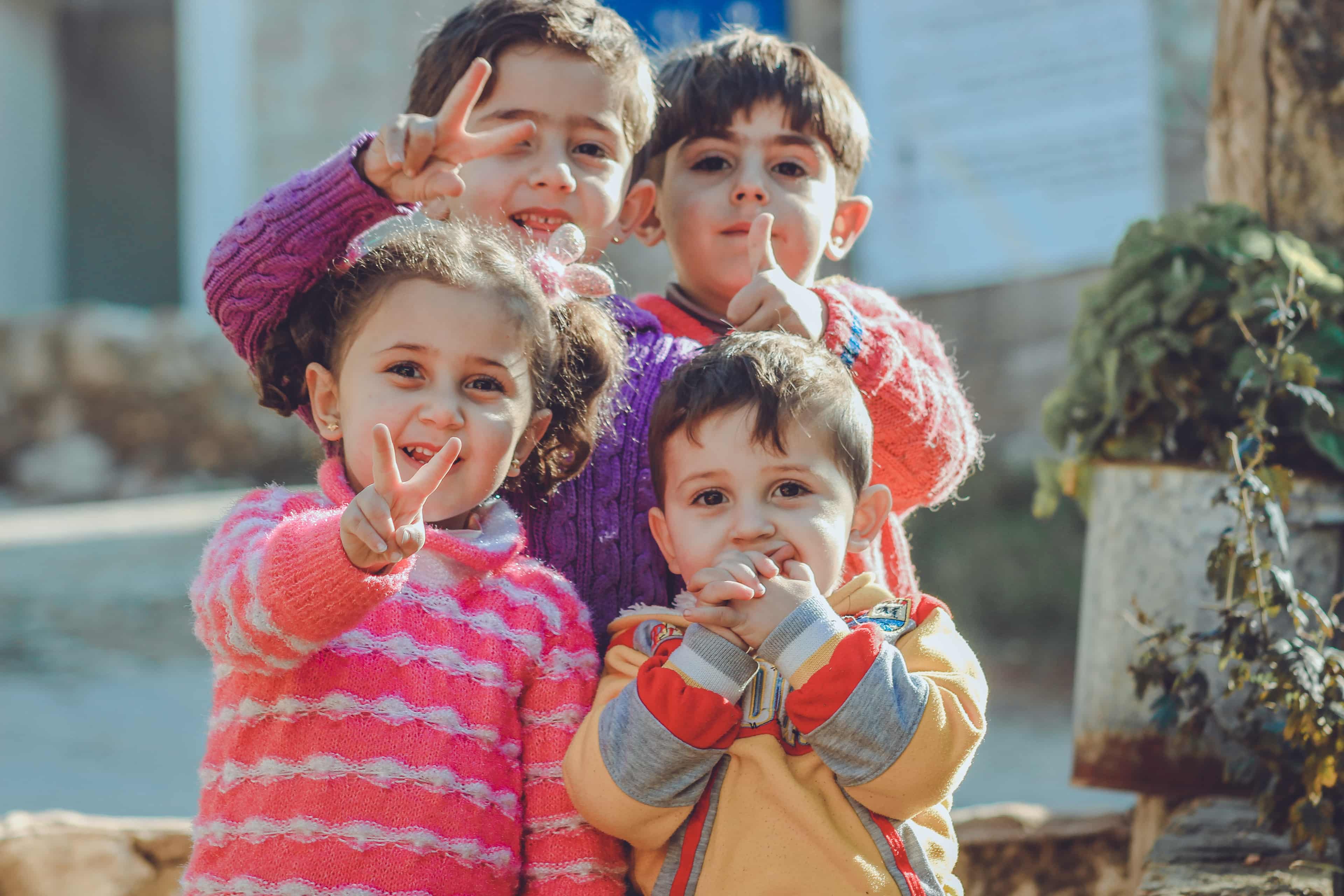 Four children making peace signs
